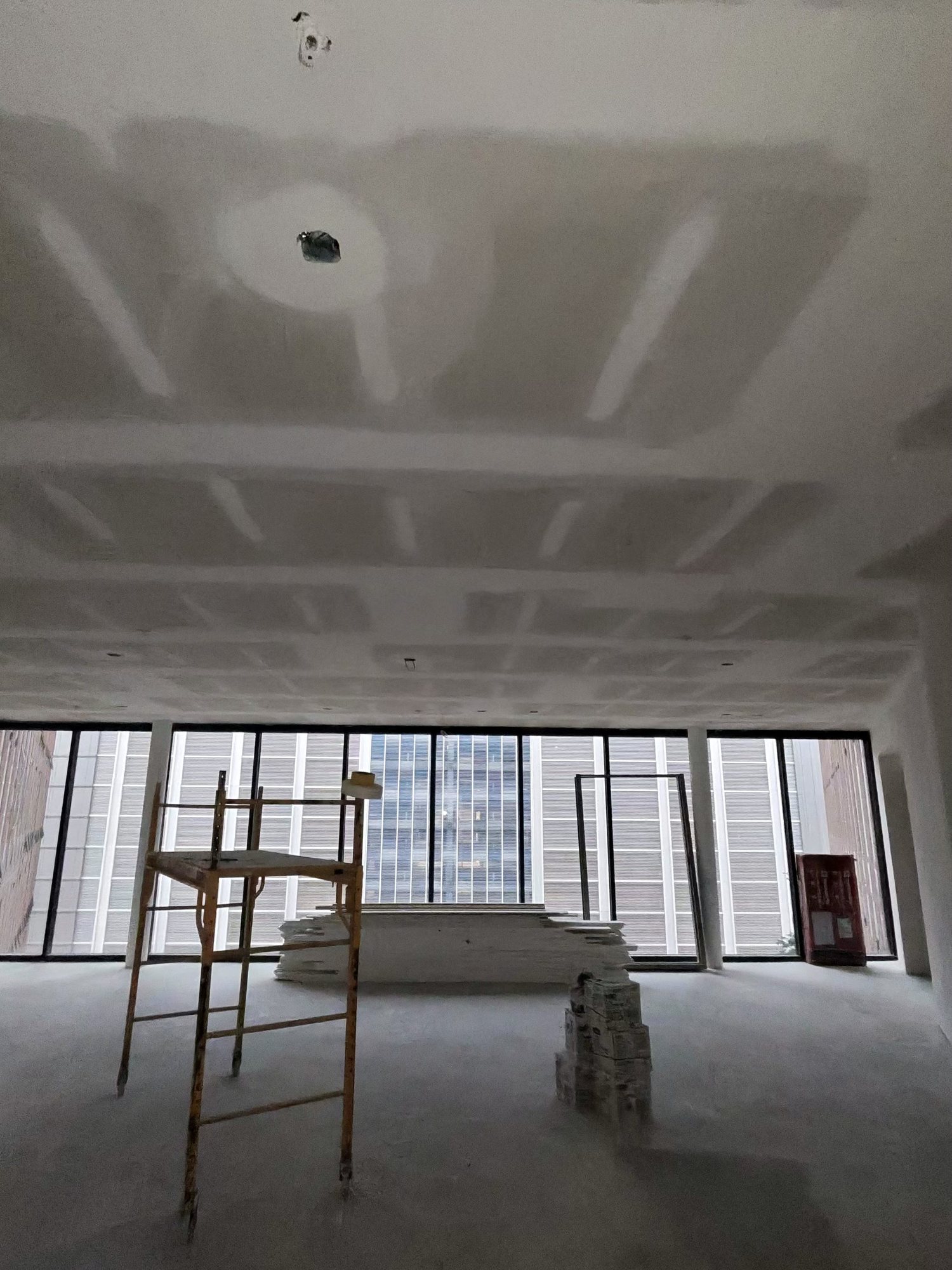 Finished drywall room with floor-to-ceiling windows, downtown high-rise