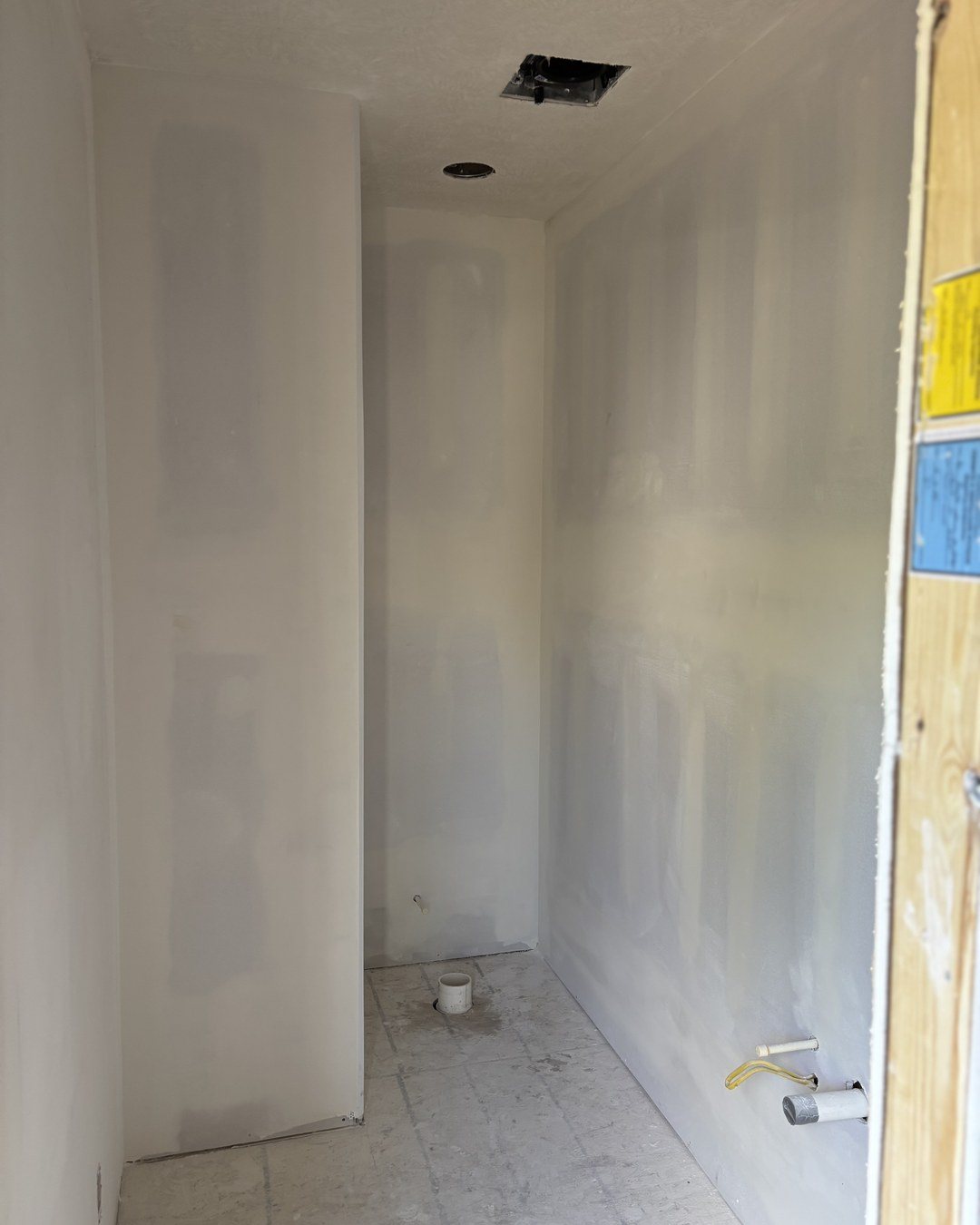 Finished bathroom wall with glass shower door, drywall repair complete